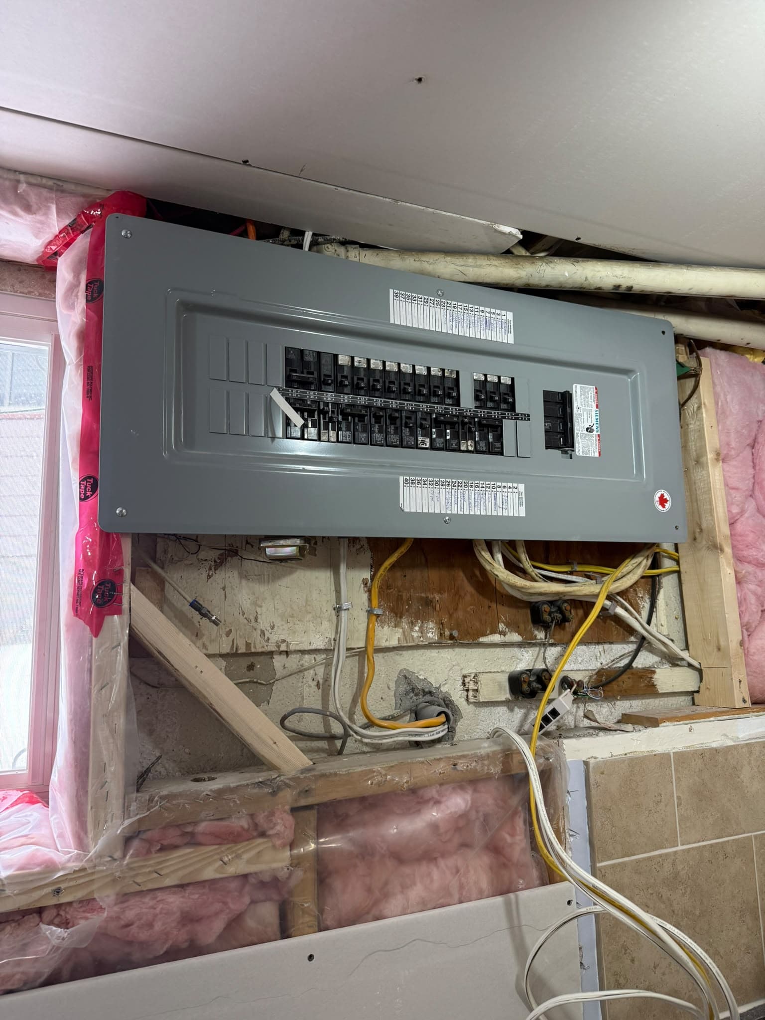 Upgraded electrical panel in the basement with the surrounding wall open